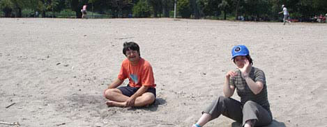 two people sitting on a beach