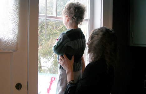 photo of mother and child looking out window