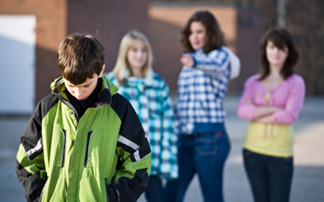 photo of girls bullying a boy at school