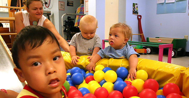 photo of child on slide holding a ball