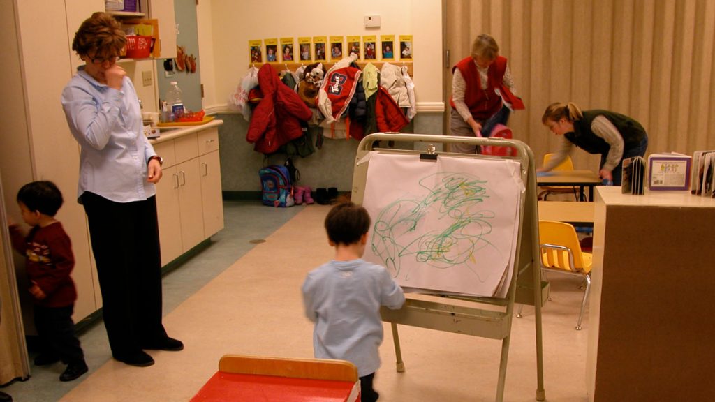 Teacher observes child drawing