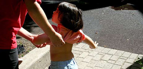 Photo of parent putting tshirt on child