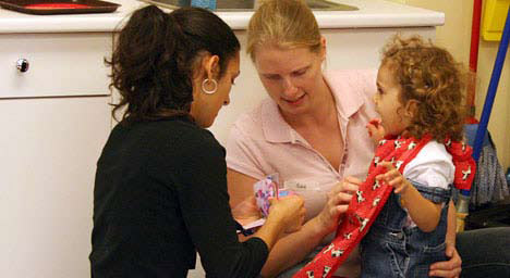 photo of daycare teachers showing a child a visual sequence